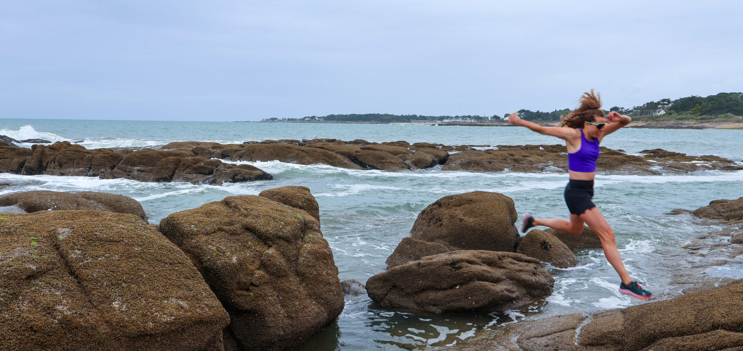 Astrid courant sur les rochers au bord de la mer